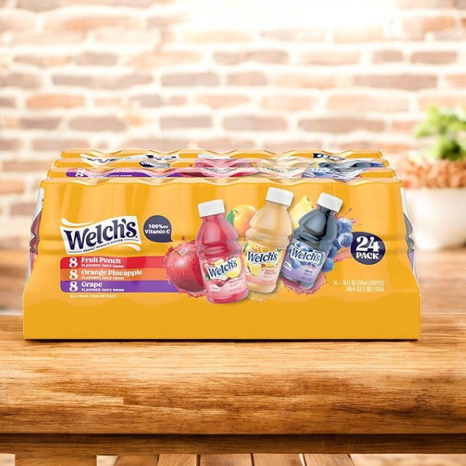 A 24-pack of Welch’s Variety Pack Juices, featuring Fruit Punch, Orange Pineapple, and Concord Grape flavors made with real fruit, is shown on a wooden surface. Product: Welch's Variety Pack Juices-24 pack-1 Case by Welch's.