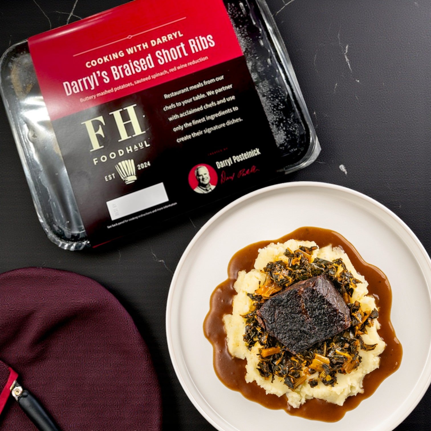 A FoodHaul Frozen Meals- Signature Chef Meal Combo – 5 Gourmet Entrées package sits beside a plated gourmet meal of braised short rib over mashed potatoes, greens, and brown gravy.