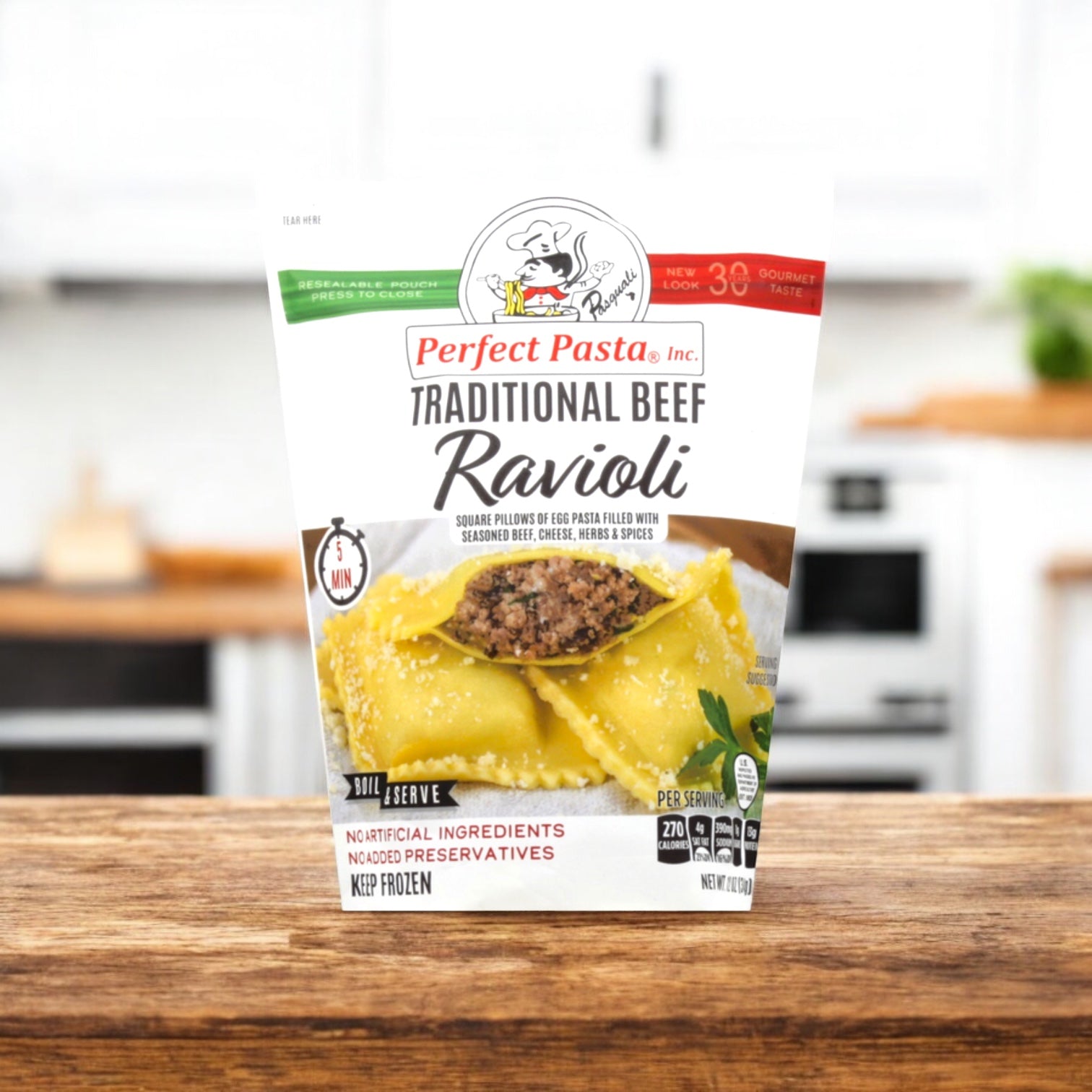 A pack of Perfect Pasta Traditional Beef Ravioli by Perfect Pasta sits on a wooden counter, adding authentic Italian flavor to your kitchen—a tasty, quick meal with a blurred kitchen backdrop.
