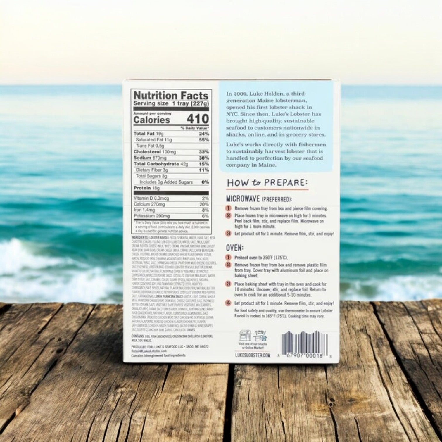 A package of Luke's Creamy Lobster Ravioli- 3 Count sits on a wooden surface by the ocean, with the back showing nutrition facts, preparation instructions, and a story about Luke's creamy lobster filling and seafood heritage.