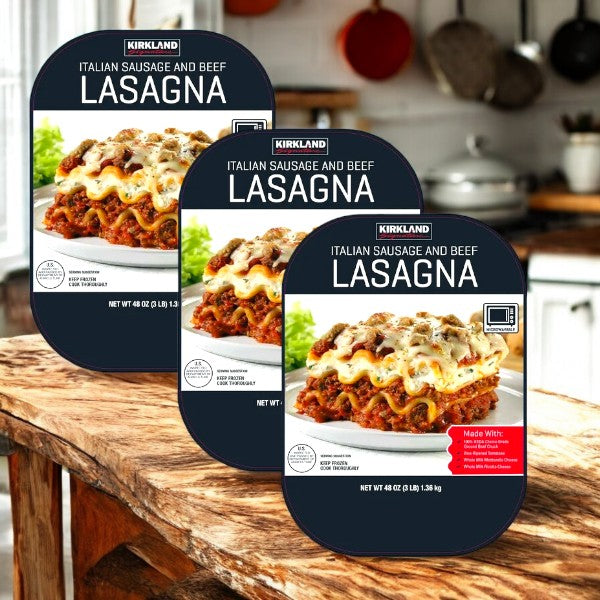 Three packs of Kirkland Signature Italian Sausage and Beef Lasagna (3 lbs, 2-count) are shown on a wood kitchen counter, with a stove and utensils in the background.