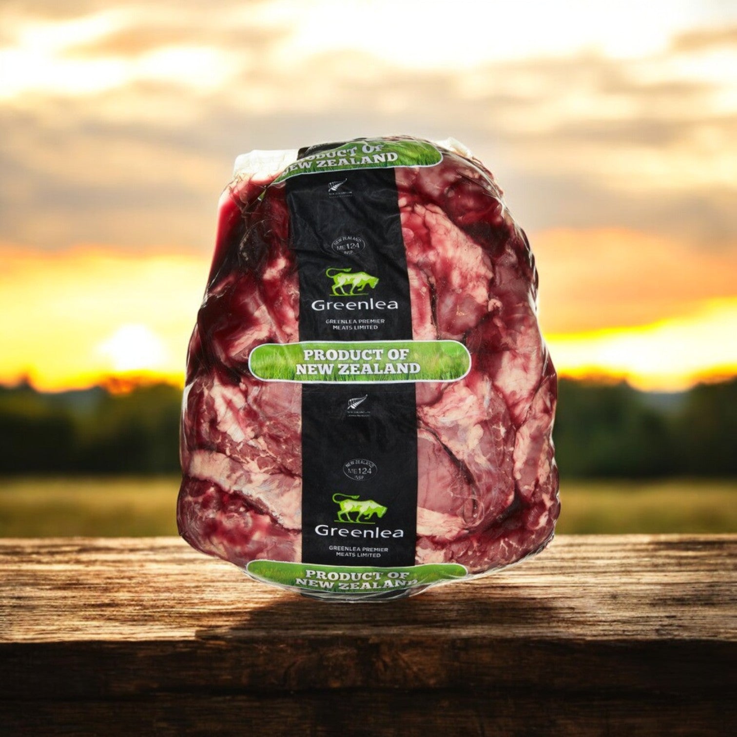 A vacuum-sealed package of Silver Fern Farms Halal Outside Skirt Steak, 6 lb Avg, labeled "Product of New Zealand," rests on a wooden surface with a blurred outdoor sunset in the background.
