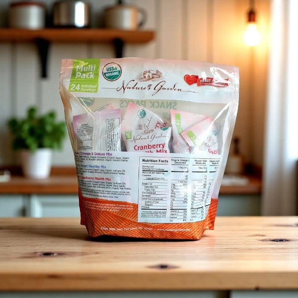A pack of Nature Garden Organic Trail Mix Snack Packs, Variety Pack, 24 Count, is displayed on a wooden kitchen table—showcasing its front and nutrition facts label as a wholesome organic snack option.