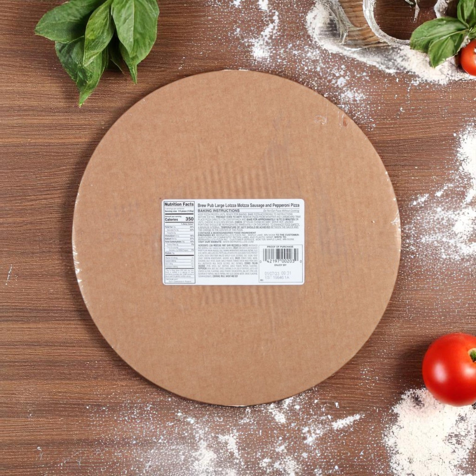 A Bernatello's Brew Pub Pizza – Sausage & Pepperoni (23.82 oz) box with a nutrition label sits on wood near flour, tomato, basil, and a pizza cutter—showcasing real Wisconsin mozzarella cheese.