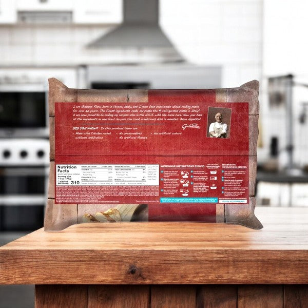 A 40 oz package of Giovanni Rana Southwest Style Linguine with Chicken and Sausage sits on a wooden counter, displaying its back with nutrition facts, cooking instructions, and a message from the creator.