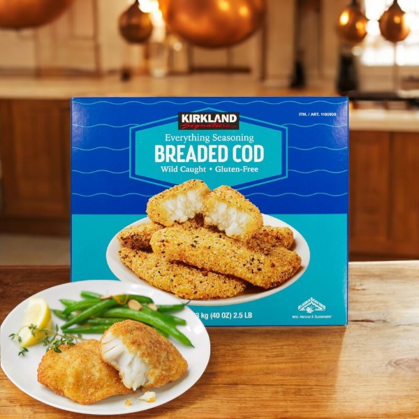 A box of Kirkland Signature Gluten Free Everything Cod, 2.5 lbs, sits on a kitchen counter with premium cod fillets and green beans served on a plate in front.