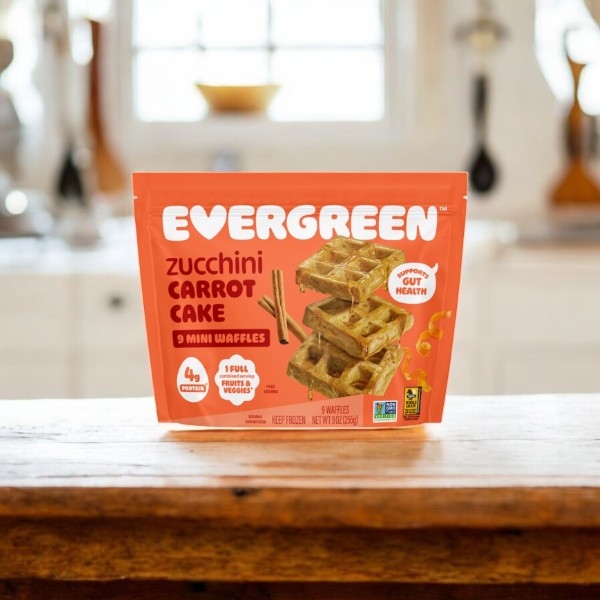 A package of Evergreen 3-Pack Combo – Mini Waffles Variety Pack, featuring frozen convenience, rests on a wooden surface with a kitchen backdrop.