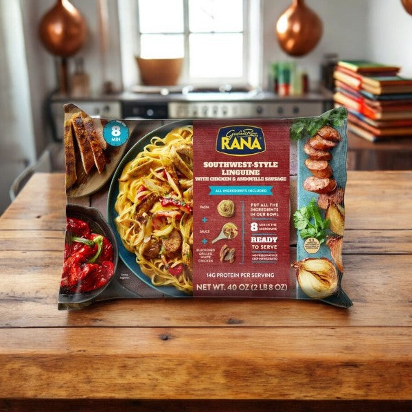 A 40 oz pack of Giovanni Rana Southwest Style Linguine with Chicken and Sausage sits on a wooden kitchen counter, with a stovetop and utensils visible in the background.