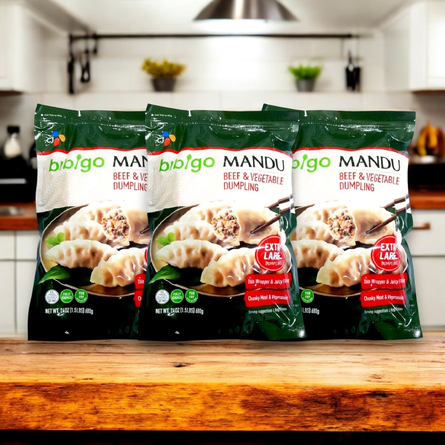 Three packs of Bibigo Mandu Beef & Vegetable Dumpling (24 oz. each) sit on a wooden kitchen counter, capturing authentic Korean flavor and offering a quick, delicious meal solution in any inviting kitchen setting.
