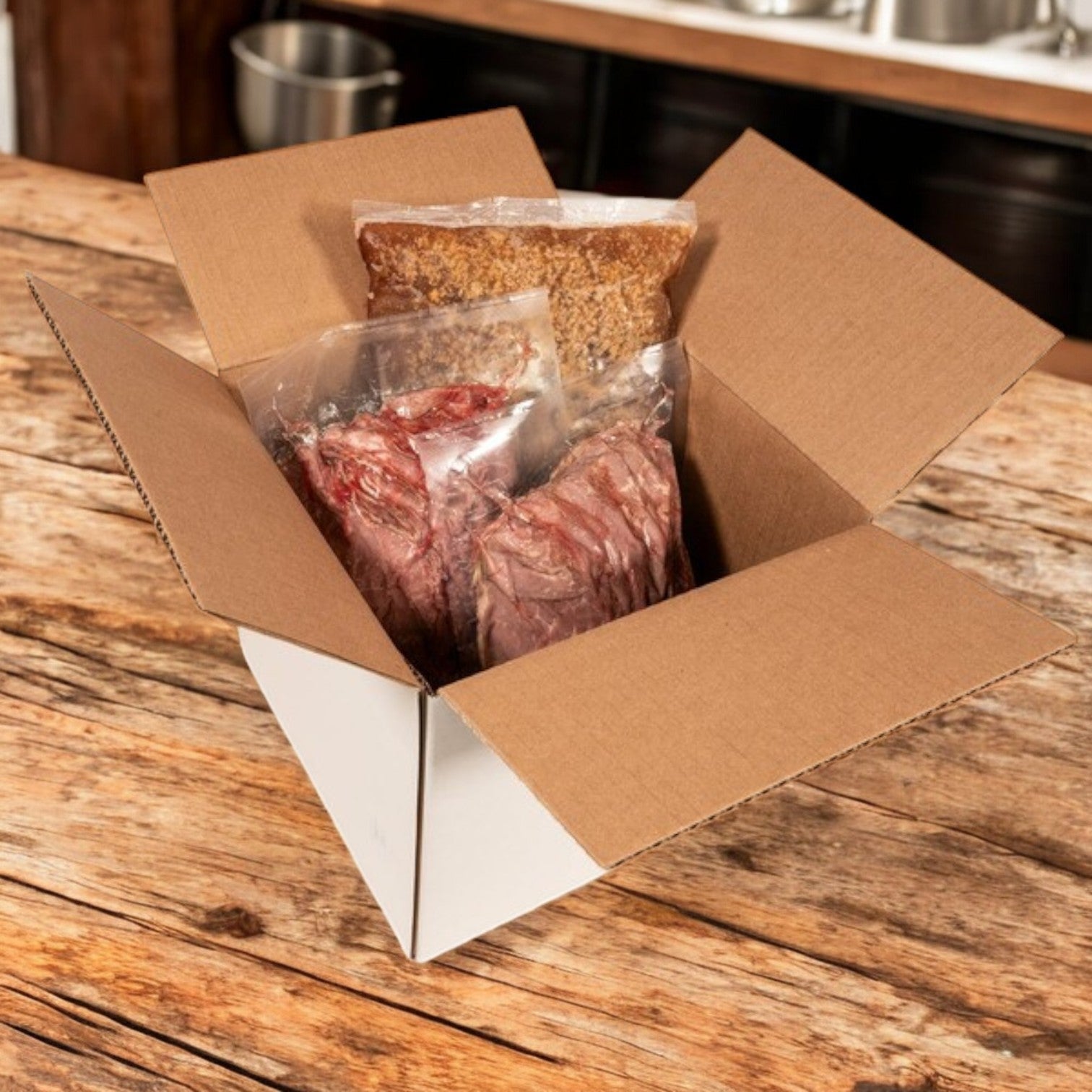 A cardboard box on a wooden table holds Devanco Sliced Italian-Style Beef with Gravy—10 lb package including 5 lb beef and 4 lb gravy, vacuum-sealed for freshness.