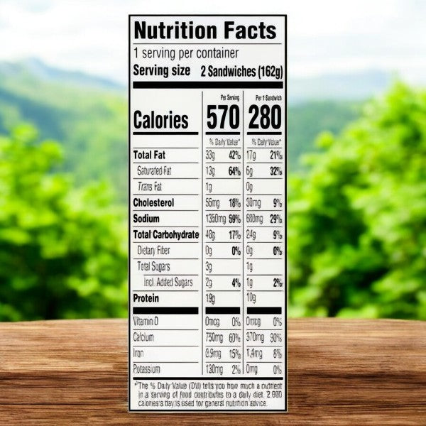 A nutrition facts label on a wooden surface with blurred greenery shows details for planning school lunches featuring Lunchables Crispy Grilled Cheesies, Original American Cheese Sandwich - 2 Pack. It provides information on calories, fat, cholesterol, sodium, carbohydrates, protein, and vitamins.