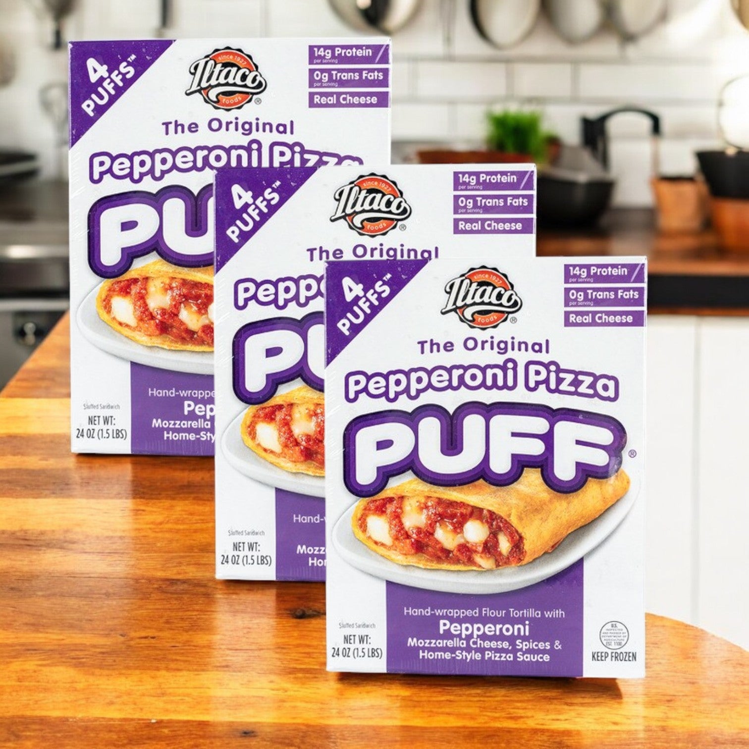Three boxes of Iltaco Foods The Original Pepperoni Pizza Puff-24 Oz-4 Count-3 Packs sit on a kitchen counter, highlighting these frozen handheld snacks with visible product details and nutrition facts on the packaging.