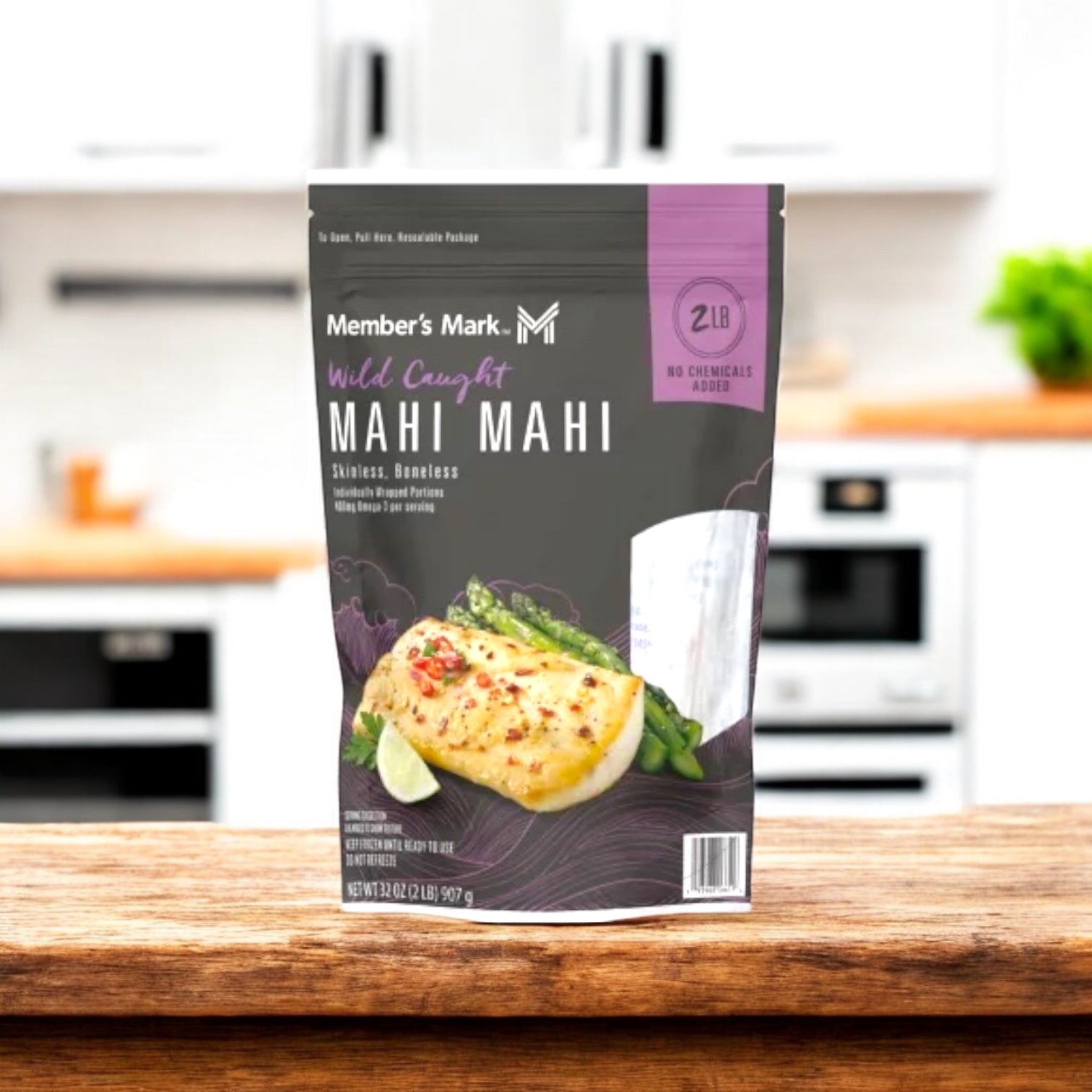 A 2-lb. bag of Member's Mark Wild Caught Mahi Mahi Portions – Skinless & Boneless (Frozen) is on a kitchen counter, with packaging showing cooked fish and veggies.