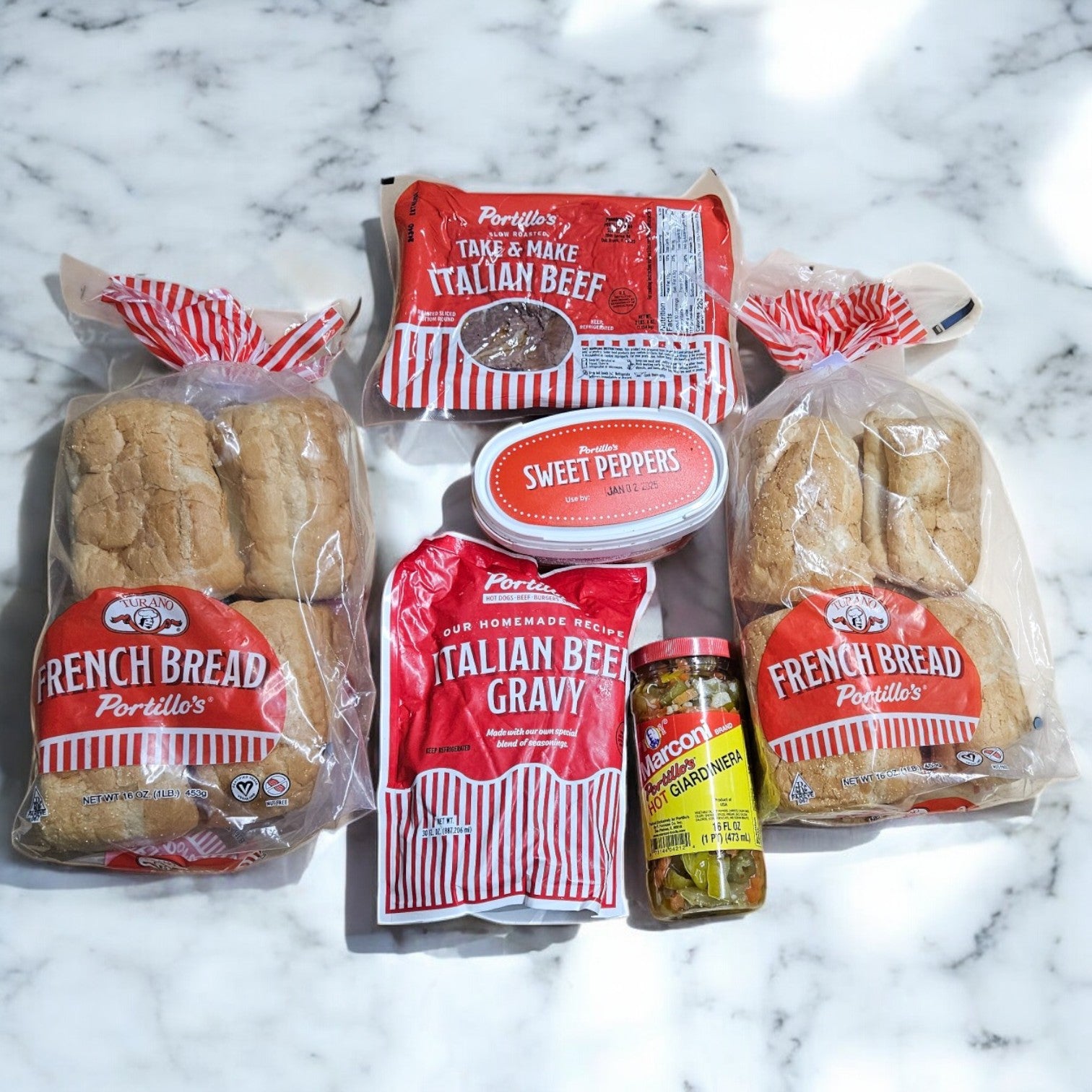 Portillo's 16 Italian Beef Sandwich Combo-Perfect For Parties is showcased with their signature Italian beef sandwiches, French bread, savory gravy, sweet peppers, and giardiniera on a marble surface, each bite delivering the authentic taste of Chicago.