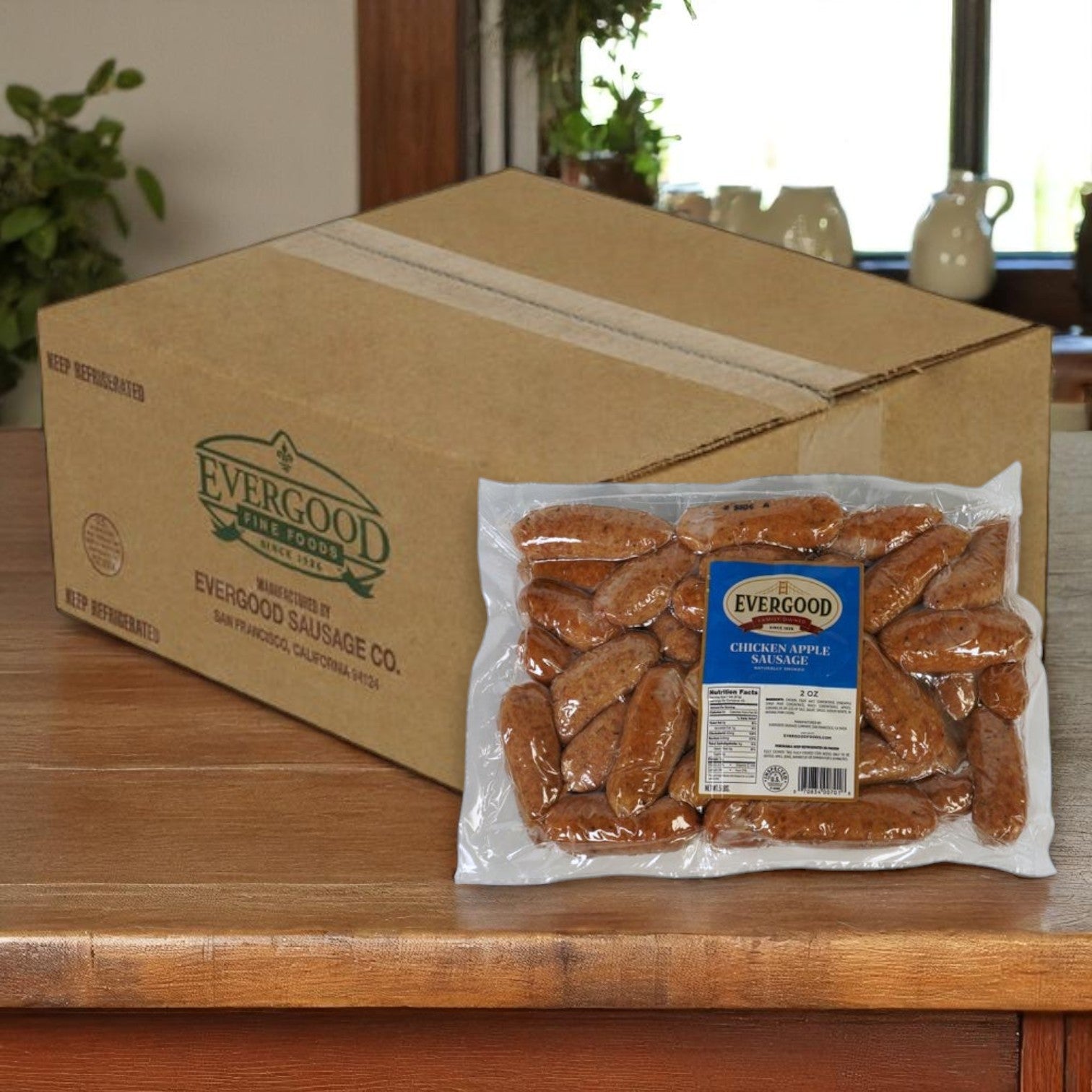 A box labeled "Evergood" sits on a counter next to a vacuum-sealed package of Evergood Chicken Apple Sausage Links – Frozen, 2 oz links, 2 packs of 5 lbs.