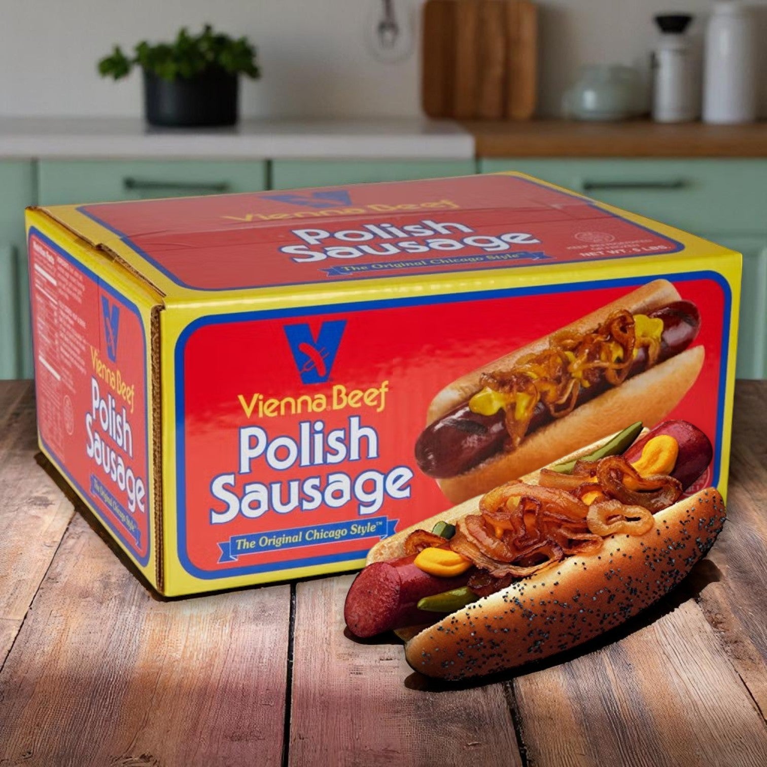 A box labeled "Vienna Beef Skinless Polish Sausage 6” 4:1 - 40 Total" by Vienna Beef sits on a table alongside two dressed sausages in buns, highlighting their classic taste; a kitchen is visible in the background.