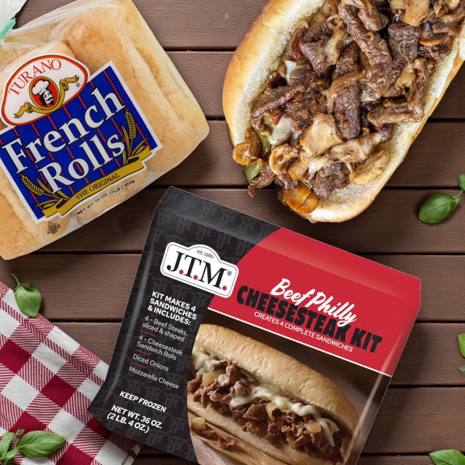 J.T.M. Beef Philly Cheesesteak Kit (2 lbs, Makes 4 Sandwiches) with Turano® French Rolls (6 ct/16 oz) and a prepared Philly-style sandwich on a wooden table with a checkered napkin.