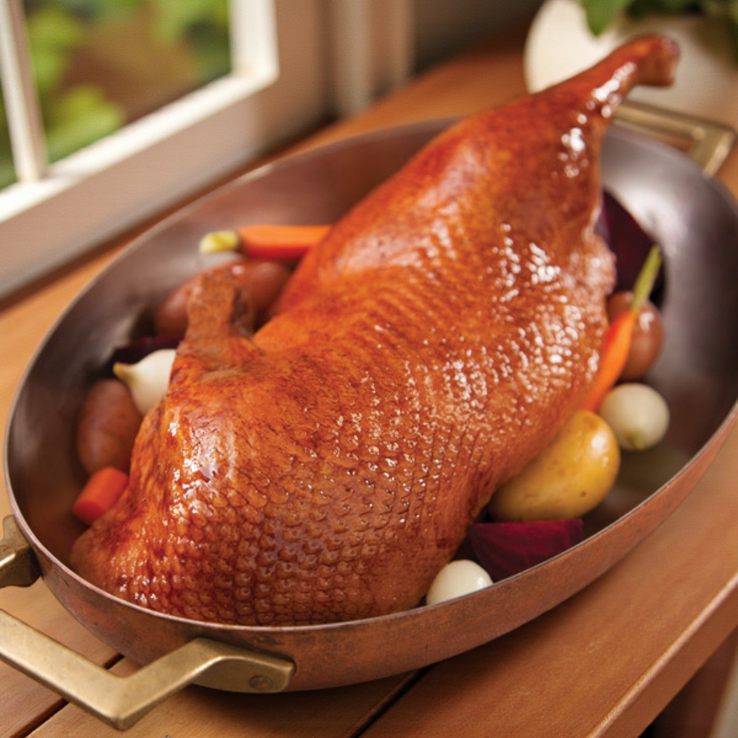 Maple Leaf Farms Half Roast Duck – 10 oz features tender duck with golden-brown skin, served in a large roasting pan alongside potatoes, carrots, onions, and beets.