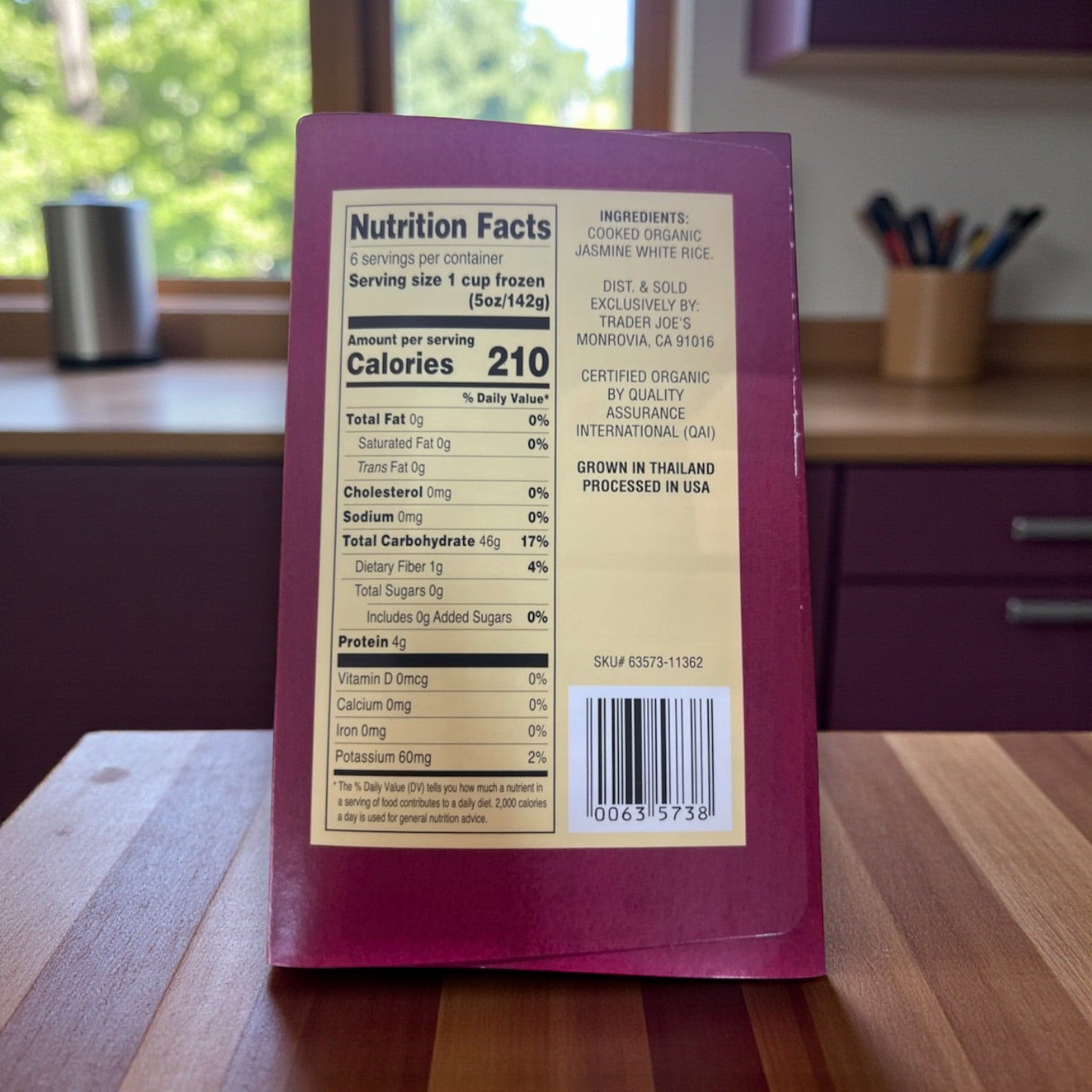 A box of Easy Lunches Trader Joe’s Organic Jasmine Rice, 30 oz – 3 Pack sits on a kitchen counter, displaying its nutrition facts and ingredients label.