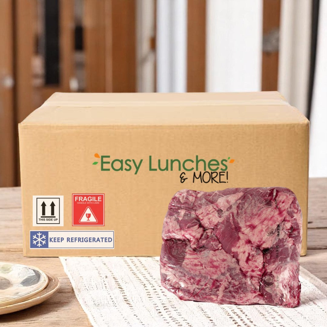A cardboard box labeled "Easy Lunches & More!" sits on a table next to a large, raw piece of Halal Flap Beef Meat-5.5 lbs-1 Case by Halal, perfectly marbled and ready to cook.