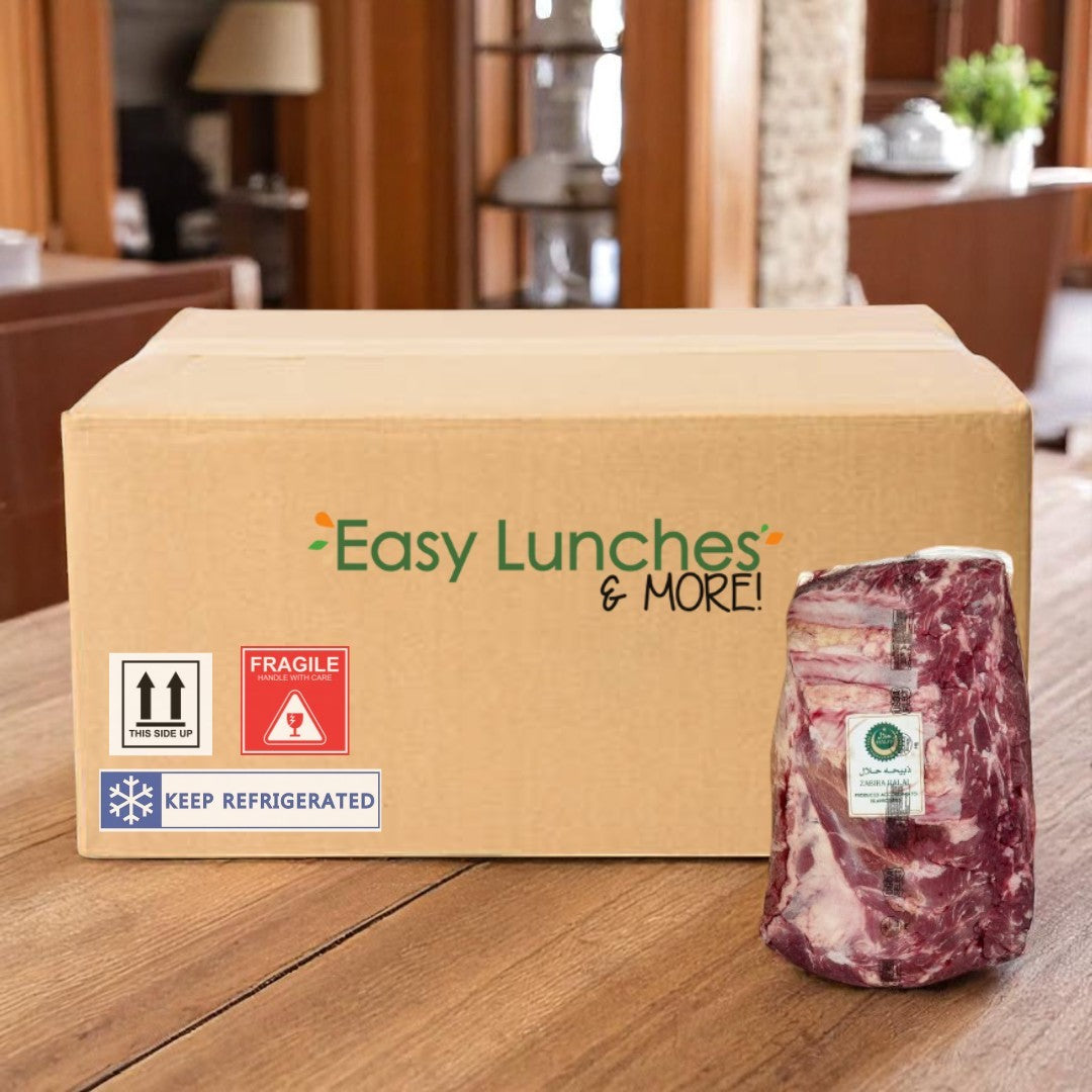 A cardboard box labeled "Easy Lunches" sits on a table next to a vacuum-sealed package of Halal Peeled Beef Tri-Tip-1.9 lbs-1 Case from Easy Lunches, available at Costco Business Center.