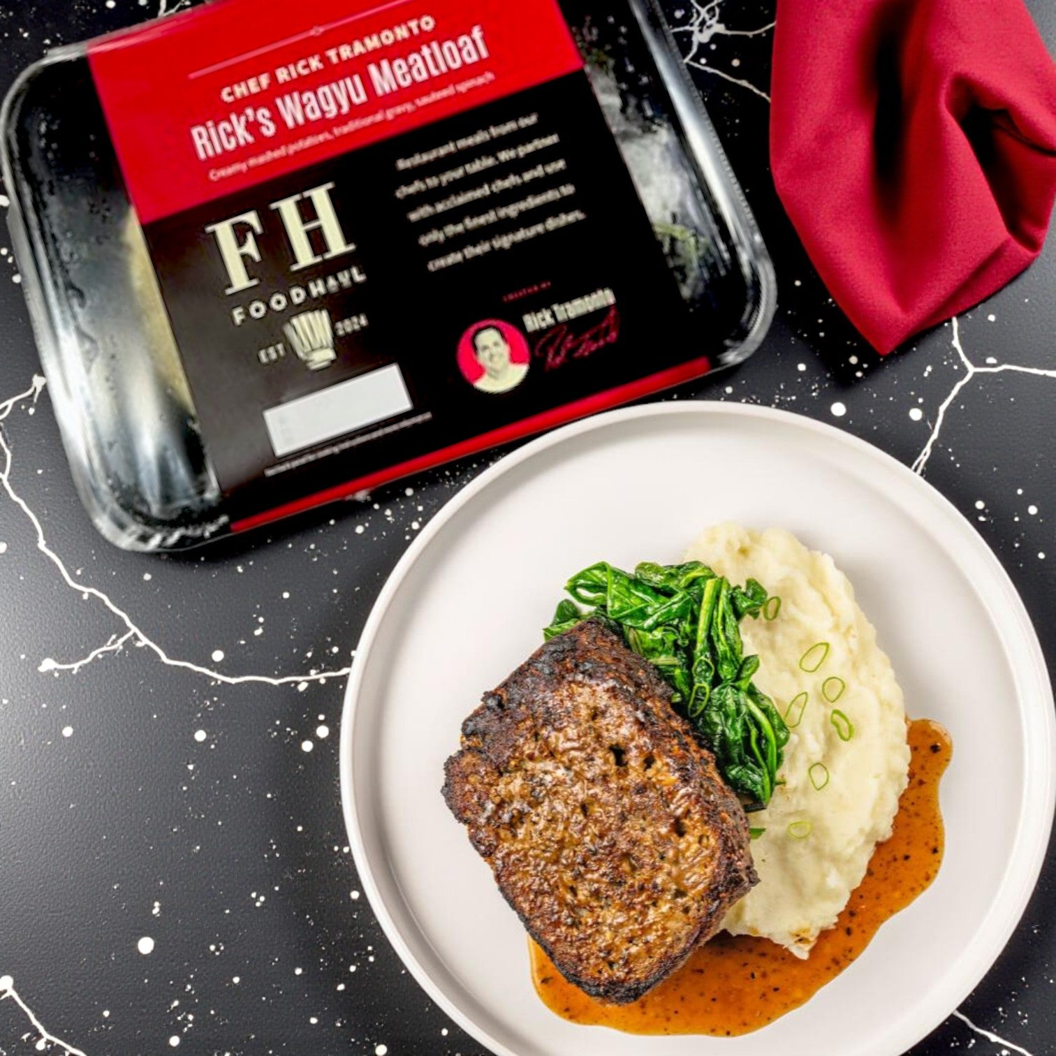 A plated chef-inspired meal with mashed potatoes, greens, and saucy meatloaf is in the foreground; a packaged FoodHaul Frozen Meals- Signature Chef Meal Combo – 5 Gourmet Entrées is displayed in the background.