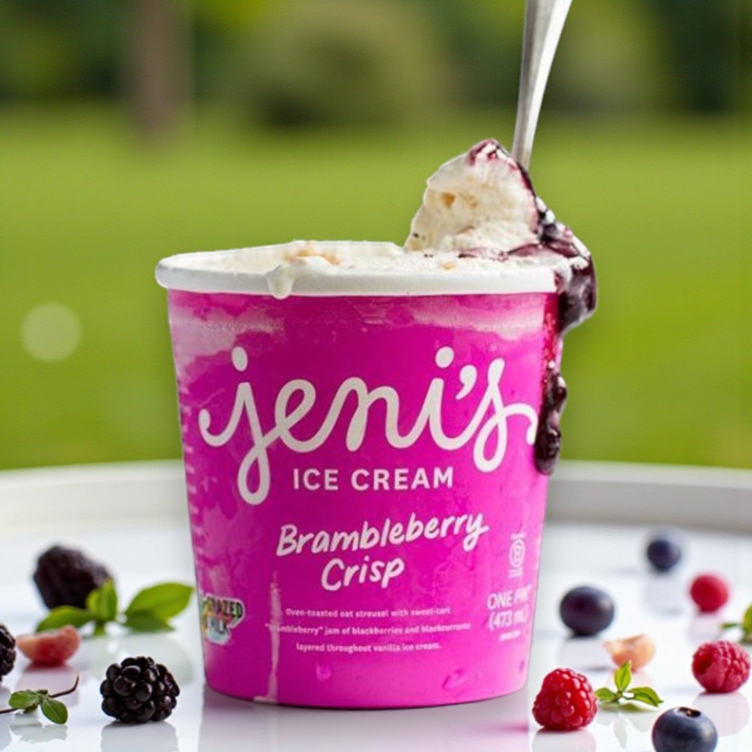 A pint from Easy Lunches’ Premium Ice Cream Lovers Combo – 6 Total Pints rests on a plate with a spoon, surrounded by fresh berries and green leaves.