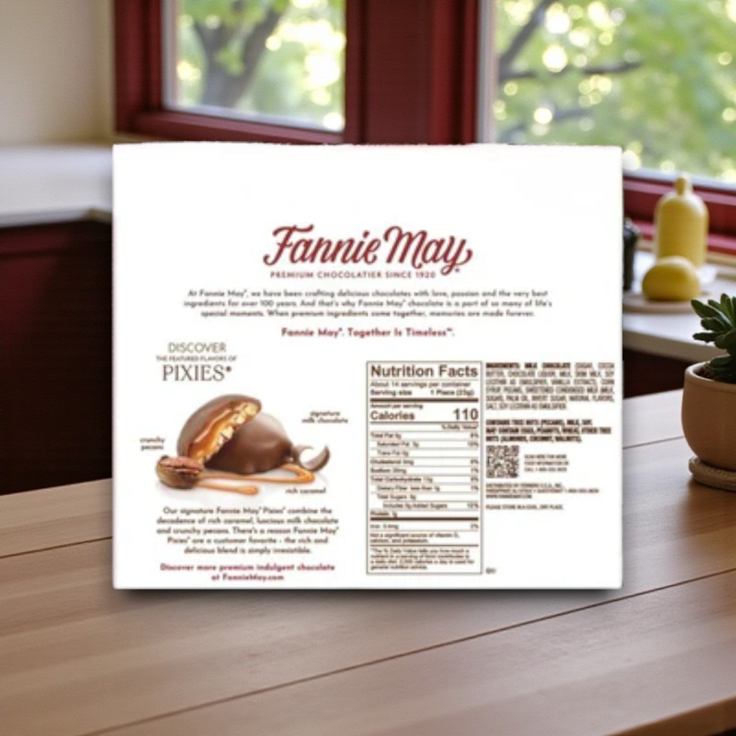 A Fannie May Chocolate Combo Pack – Pixies & Mint Meltaways (2 Count) sits on a wooden table, showing product and nutrition info—ideal for enjoying by the kitchen window.