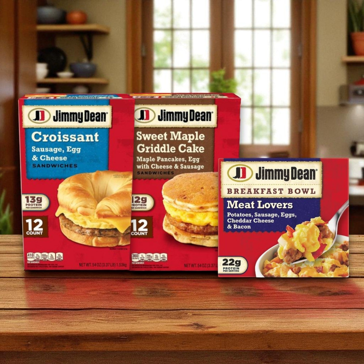 A Jimmy Dean Breakfast Variety Pack featuring Griddle Cake Sandwiches, Croissant Sandwiches, and Meat Lovers Bowls (8 or 12 count) is displayed on a wooden table in a kitchen setting.