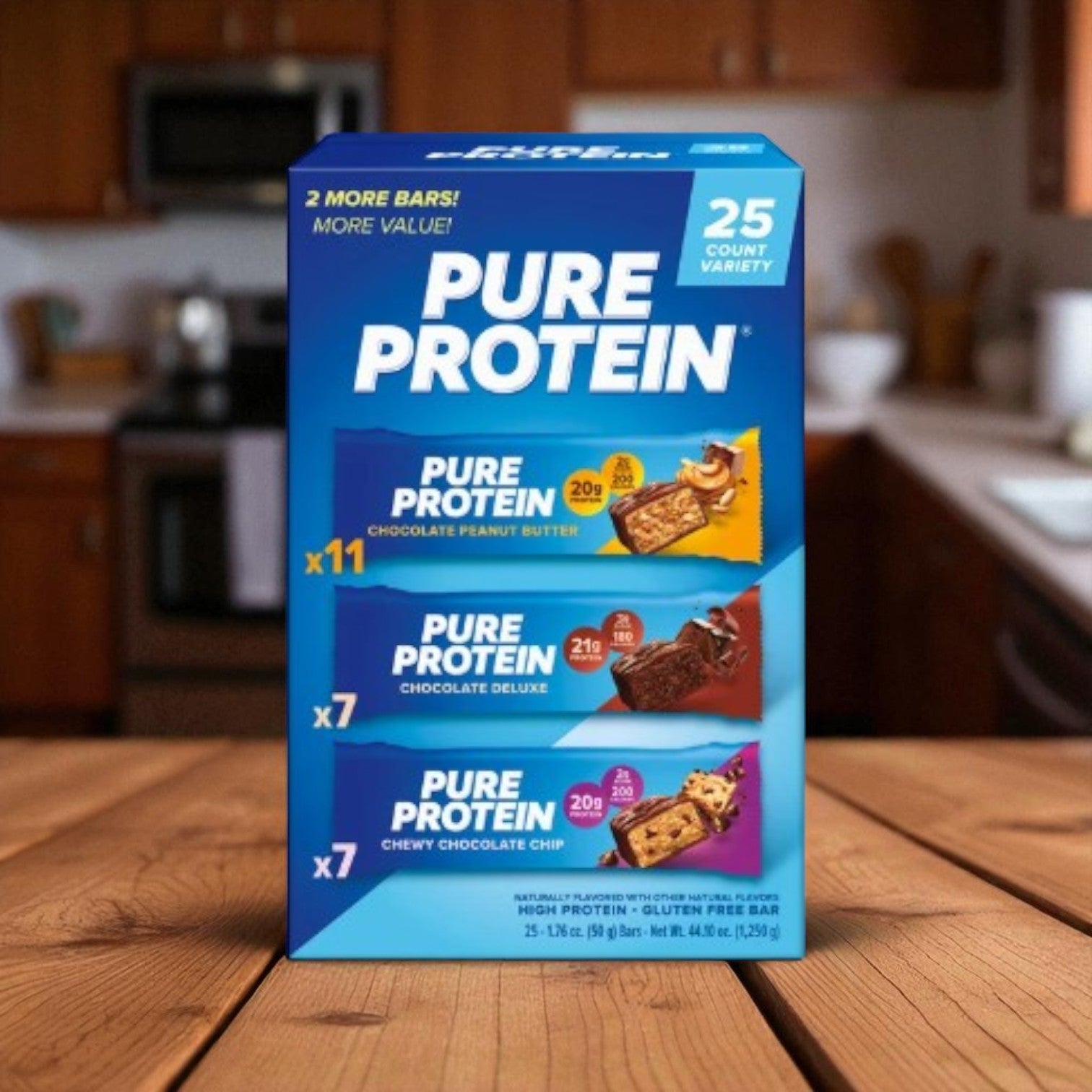 A 25-count Easy Lunches Pure Protein Bars Variety Pack with low-sugar, high-protein bars in Chocolate Peanut Butter, Chocolate Deluxe, and Chewy Chocolate Chip flavors displayed on a kitchen counter.