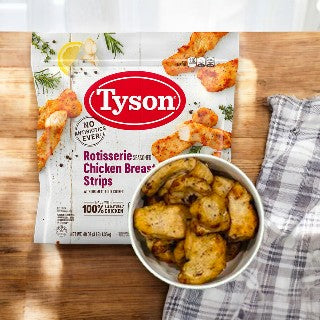 A package of Tyson Rotisserie Seasoned Unbreaded Chicken Breast Strips is next to a bowl filled with cooked chicken breast strips, set on a wooden surface with a cloth napkin beside them.