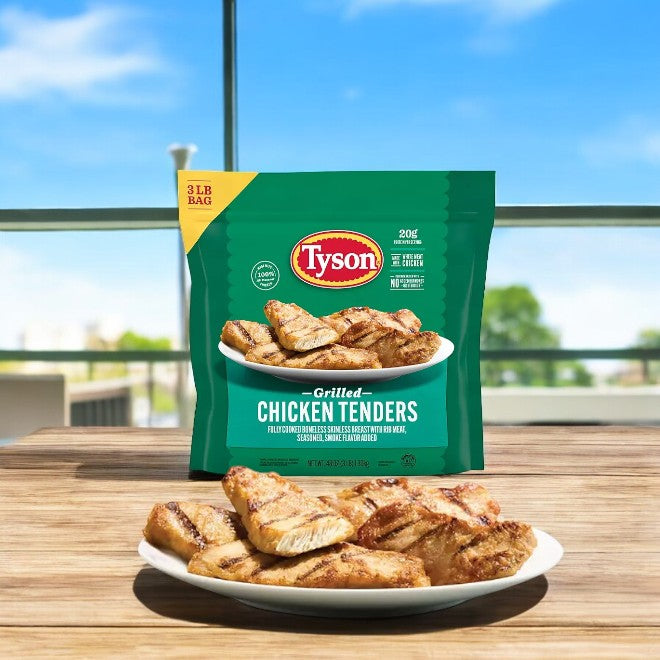 A 3-pound bag of Tyson Grilled Chicken Tenders is showcased on a table with a plate of high-quality, protein-rich tenders in front, set against a backdrop of blue sky and trees.