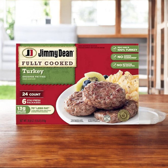 The packaging of Jimmy Dean Fully Cooked Turkey Sausage Patties, which includes 24 patties in one case, is shown on a wooden table. They are ideal for a protein-rich breakfast.