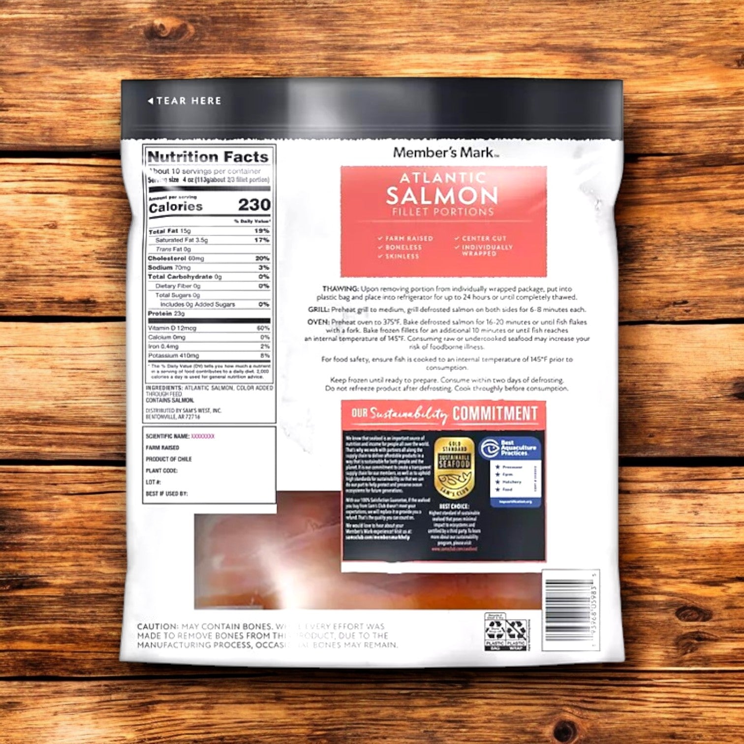 The back of Member's Mark Salmon Fillet Portions, 4 oz., showcases nutrition facts, omega-3 content, and cooking instructions on a wooden surface while emphasizing sustainable fisheries.