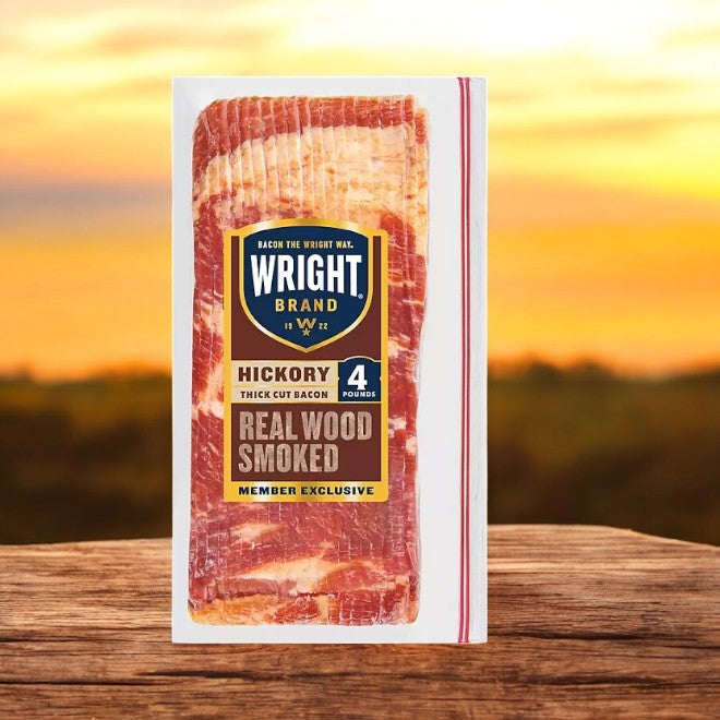 A package of Wright Brand Thick Sliced Hickory Smoked Bacon, 4 lbs, is set against a stunning sunset, showcasing its rich flavor and smoked perfection to enhance any meal.