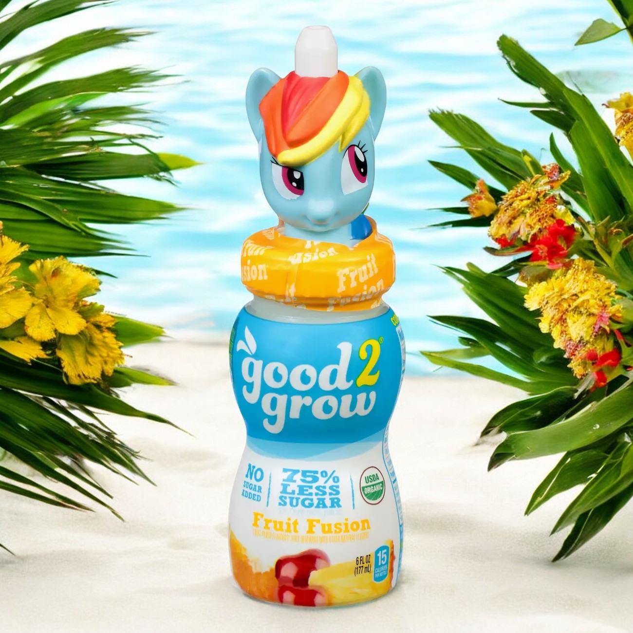 A bottle of Easy Lunches Good2grow Fruit Fusion Juice, Single Serve 6 oz with 75% less sugar, featuring a collectible My Little Pony character cap, placed on a sandy surface with tropical plants and shimmering water in the background. Enjoy the fun and flavor of 100% real fruit juice in each sip!