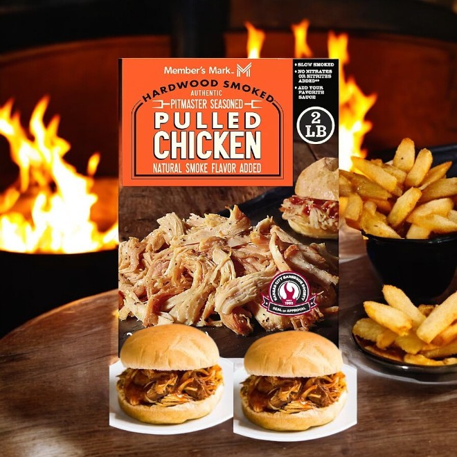 The packaging of Member's Mark Seasoned Pulled Chicken-1 Count is showcased with sandwiches in the foreground, accompanied by fries and a firepit in the backdrop.