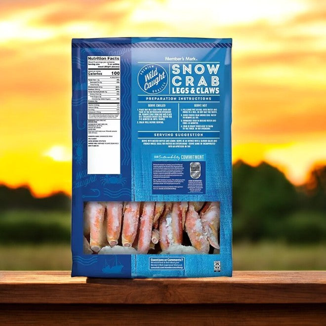 A package of Member's Mark Snow Crab Legs and Claw-1 Count rests on a wooden surface, encapsulating the ultimate seafood experience against a backdrop of a sunset and blurred landscape.