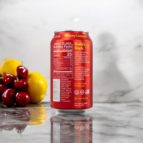 A can of Poppi - Prebiotic Soda Cherry Limeade, 1-12 fl oz, sits on a marble surface, with text detailing nutrition facts and ingredients. Lemons and cherries are grouped in the background.