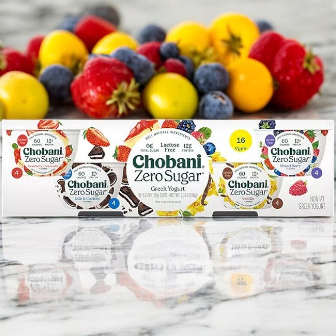 Chobani Zero Sugar Nonfat Blended Greek Yogurt Variety Pack- 1 Case sits on a marble countertop, with colorful fruits in the background.