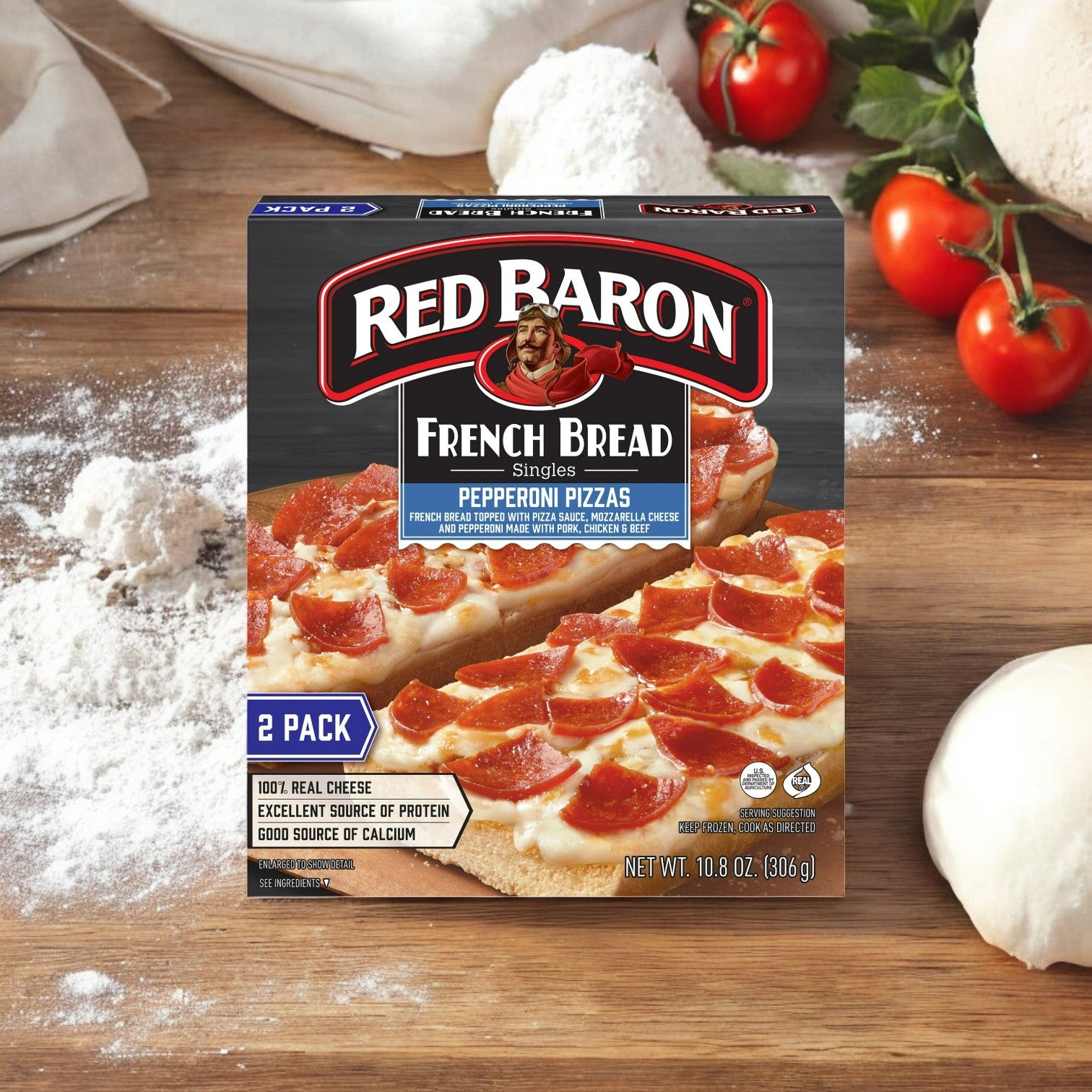 Three boxes of Red Baron Pepperoni French Bread Personal Frozen Pizza, totaling six pizzas at 10.8 oz each, rest on a wooden surface surrounded by flour, tomatoes, and dough; the savory pepperoni and melted mozzarella cheese take center stage.