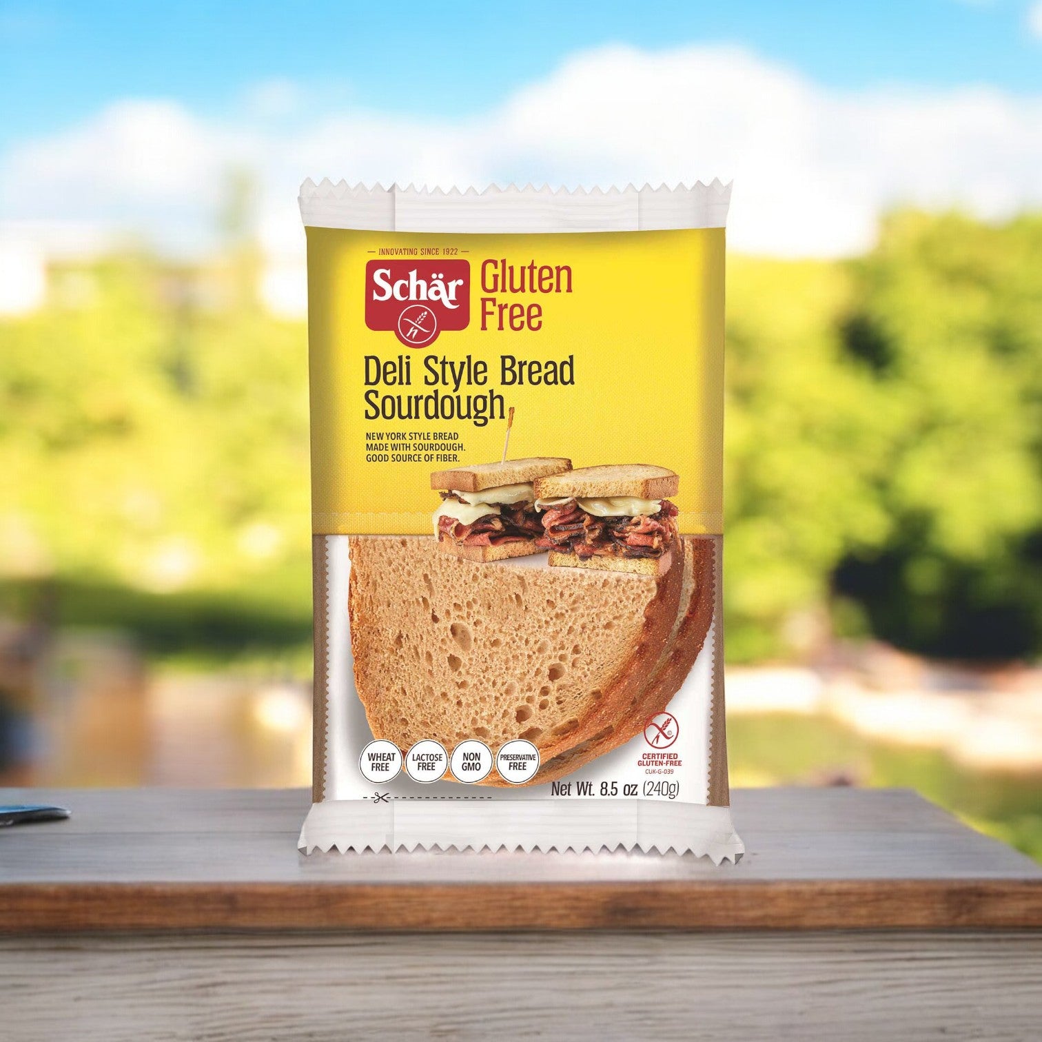 A package of Schar Gluten Free Deli Style Bread, part of an 8.5 oz. set with four per case, rests on a wooden table, ideal for crafting your favorite gluten-free sandwich. The natural background enhances the simplicity and appeal of this delightful bread option.