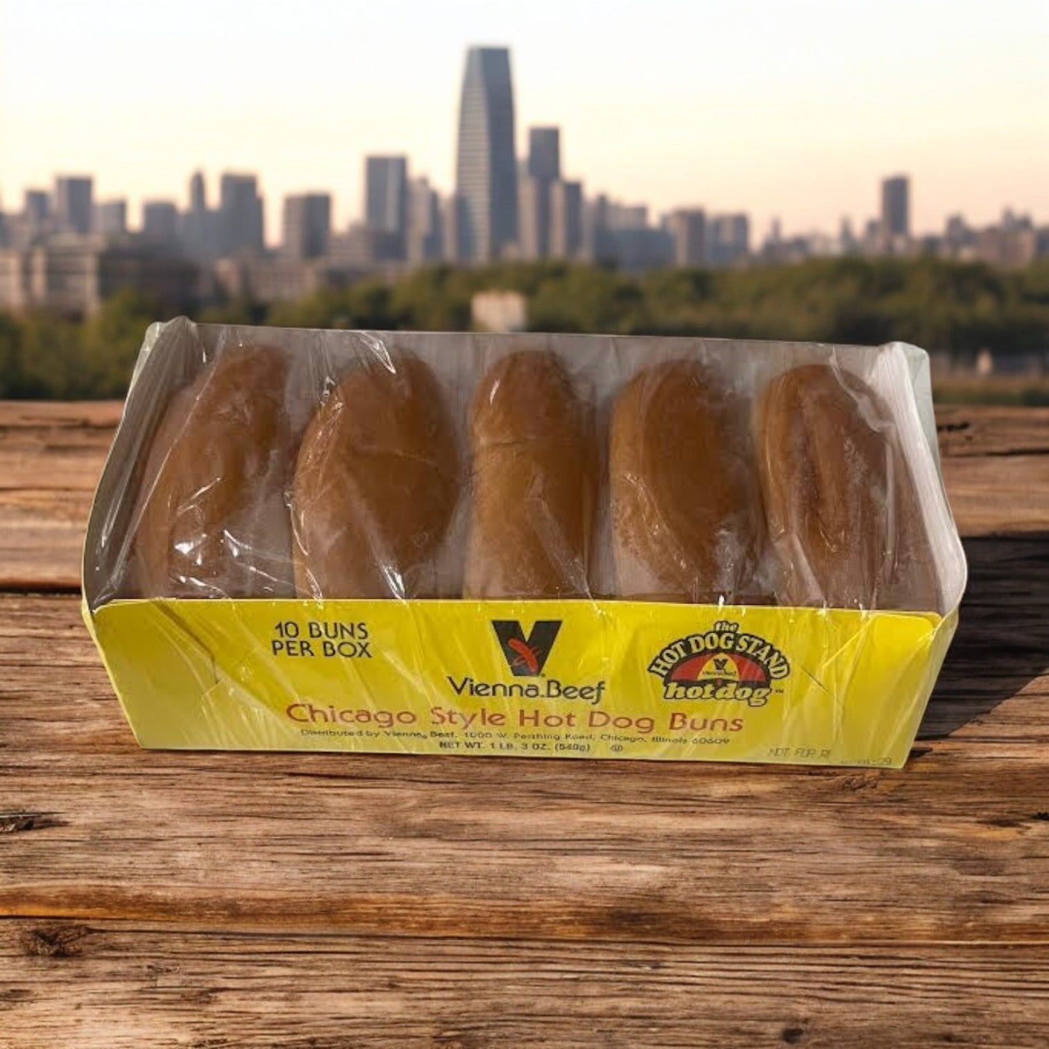 A case of Vienna Beef Plain Hot Dog Buns includes 12 packs, each with 10 classic buns, for a total of 120 buns—pictured on a wooden surface with a city skyline in the background.
