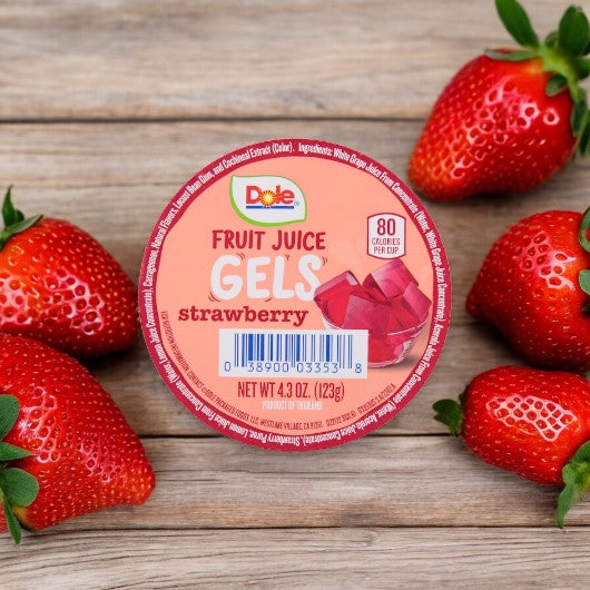 A container of Dole Wiggles Strawberry Fruit Juice Gels, 4.3 oz - 1 Count, from the brand Dole, sits on a wooden surface surrounded by fresh strawberries. Packed with Vitamin C, this delightful treat has a net weight of 4.3 oz (123g).