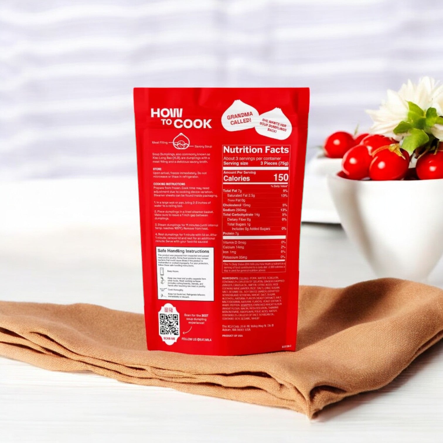 A red-packaged food item, labeled as MiLa Pork Soup Dumplings, Frozen, 8.8 oz, 10 Count - 3 Bags from the brand Mila, displays nutritional information and sits on a brown cloth. In the background, a white bowl with red and white decorative objects adds an authentic touch of Chinese cuisine charm.