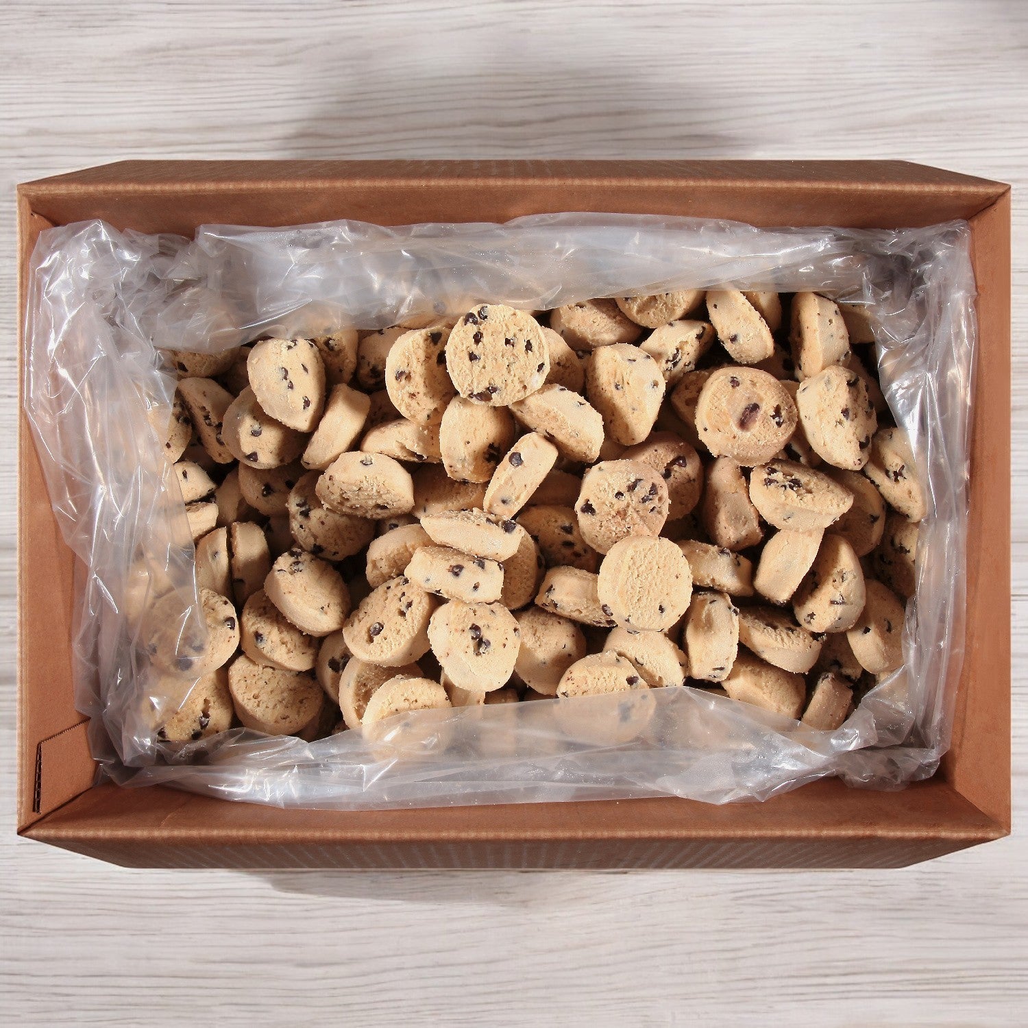 A cardboard box containing Otis Spunkmeyer Chocolate Chip Cookie Dough, with 320 individually wrapped 1 oz. portions, made with premium ingredients.