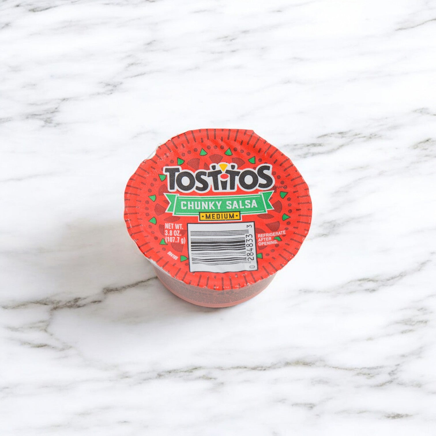 A Tostitos Medium Salsa To-Go Cup from the 30-pack (3.8 oz each) rests on a marble surface, offering zesty flavor ideal for pairing with tortilla rounds.