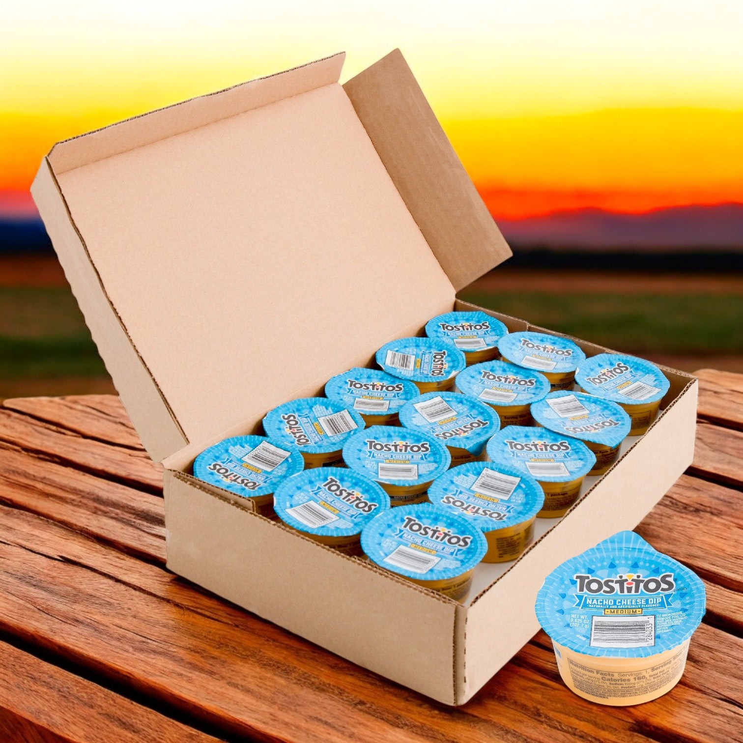 A box of Tostitos Nacho Cheese Dip Cups – 30 Pack (3.625 oz each) sits invitingly on a wooden table, the sunset casting a warm glow, suggesting the zesty flavor inside. It's perfect with tortilla rounds or a touch of Tostitos Salsa Verde for an extra kick.