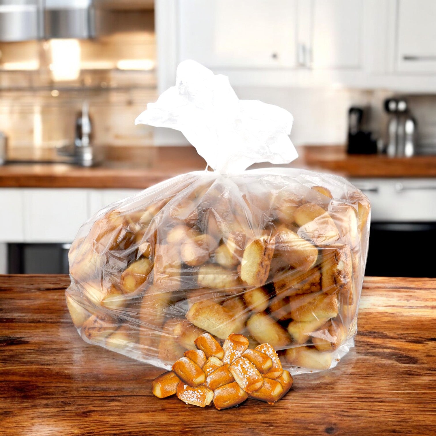 On a wooden kitchen counter sits a transparent bag of Super Pretzel's SUPERPRETZEL Soft Baked Pretzel Bites (375 Count, 0.31 oz each), with more bites enticingly scattered in front.