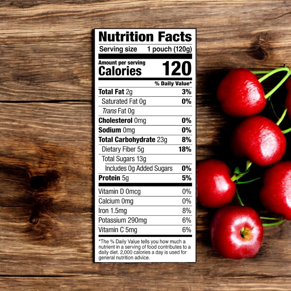 A nutrition label on a wooden surface with a Noka Organic Cherry Acai Smoothie. The label shows a serving size of 120g and 120 calories, with 0g of fat, cholesterol, and sodium. It also details vitamins, minerals, and highlights that this antioxidant-rich smoothie is organic and vegan.